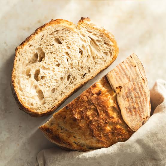A fresh sourdough loaf cooling on a wire rack